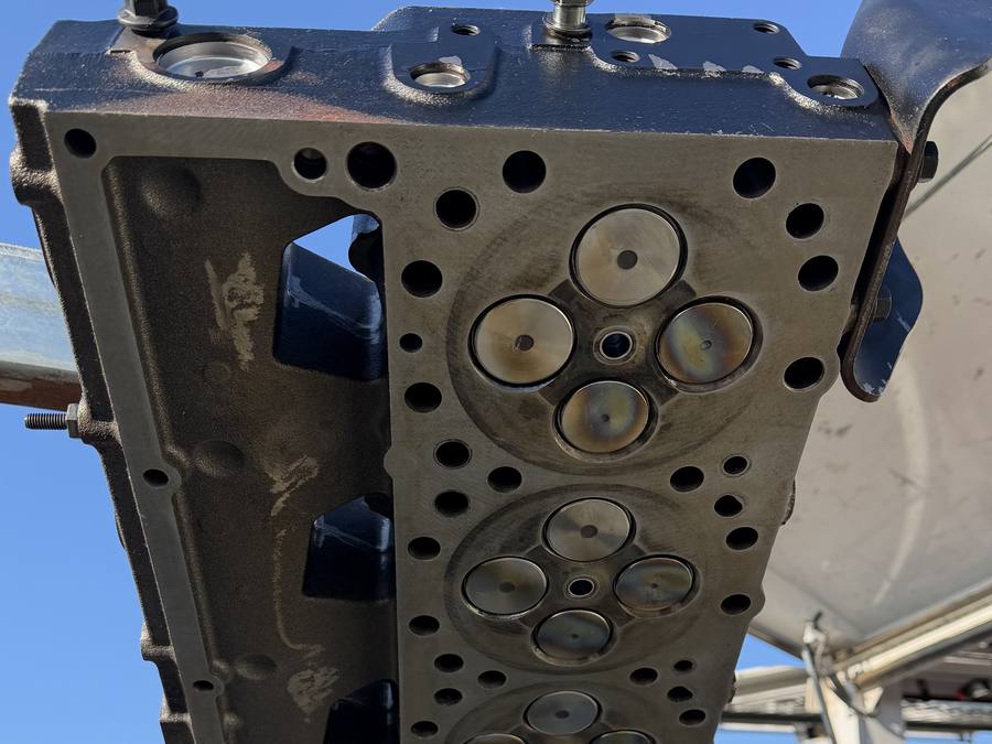 A diesel cylinder head lifted clear, showing the valve seats and combustion faces